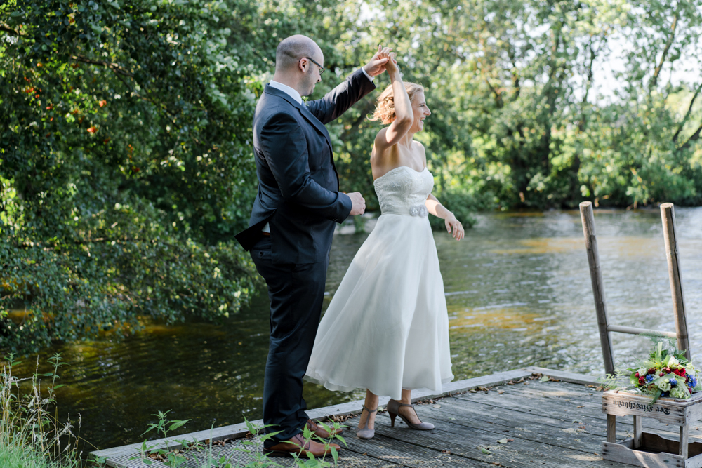 Paarfotos bei der Hochzeit - Ein Tanz auf einem Steg am See