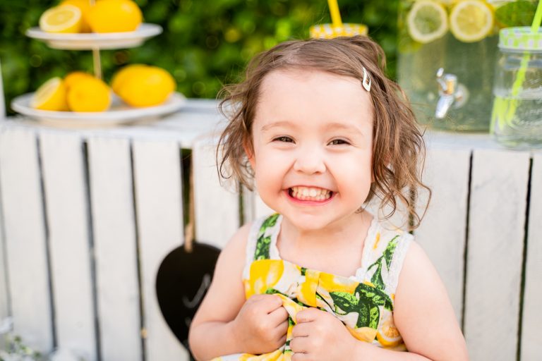 Lachendes Kind beim Fotoshooting mit Zitronen
