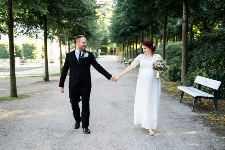 Brautpaar geht gemeinsam durch eine Allee spazieren Hochzeitsfotografin bremen