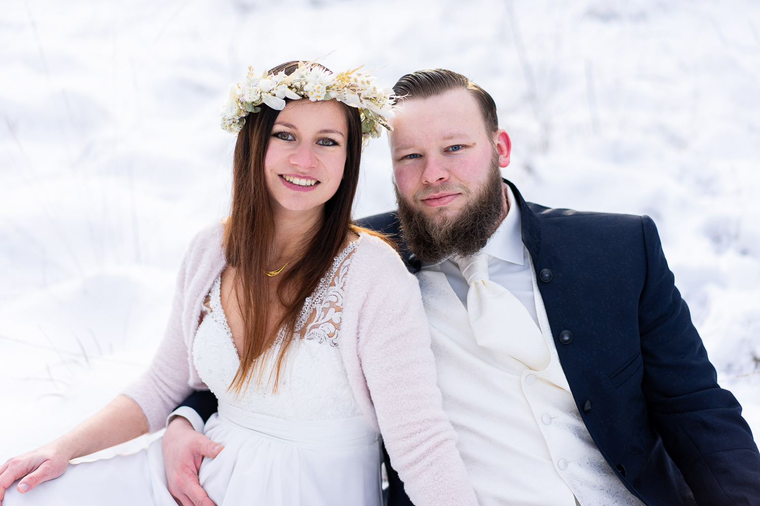 Hochzeitsfotografin bremen Hochzeitsfotos im Schnee Brautpaar sitzt im Winterwunderland